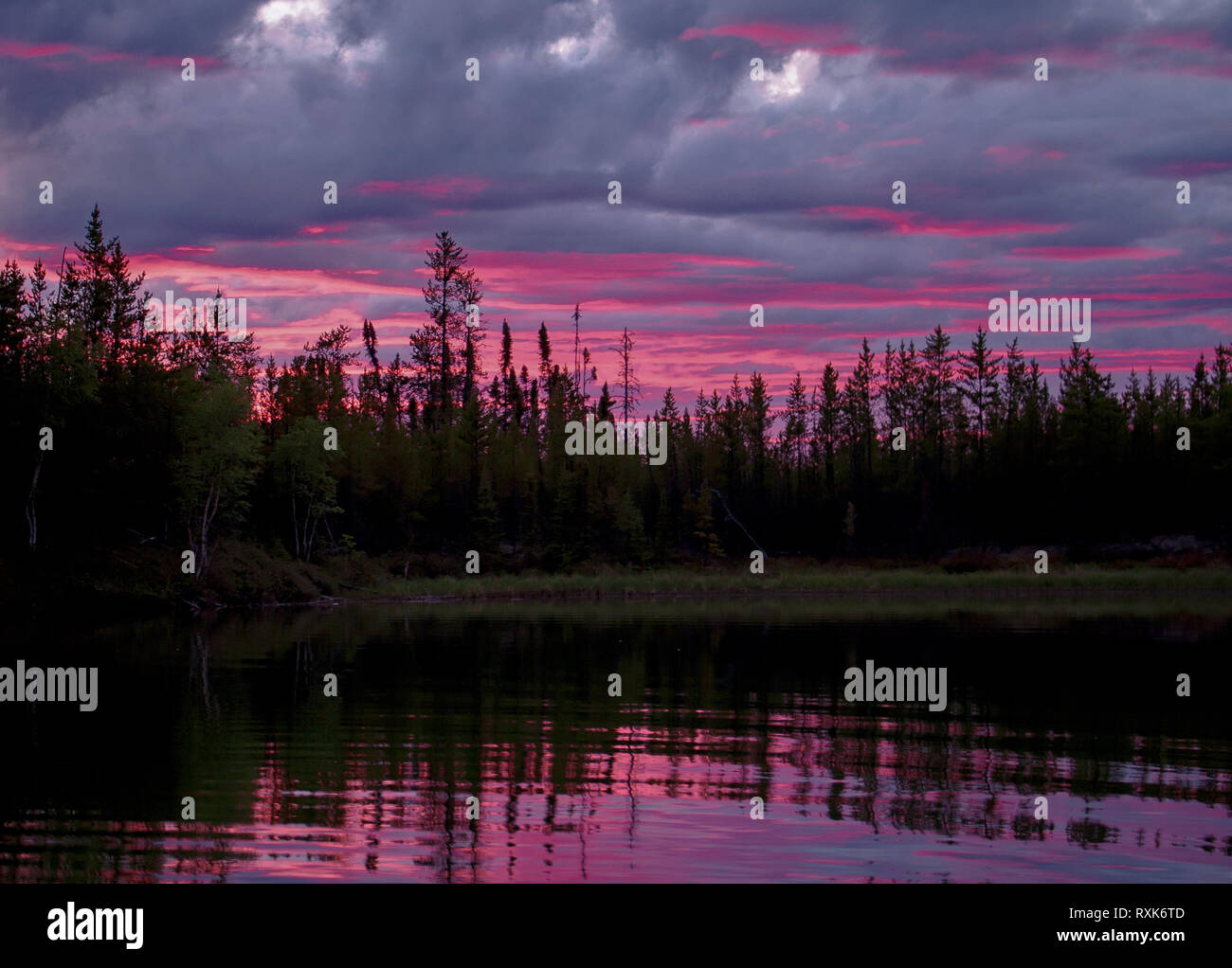 A Canadian sunset turns the clouds pink in northern Saskatchewan Stock