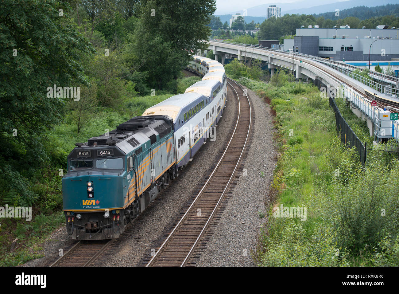 A Westcoast Express commuter train is lead by a VIA locomotive in Coquitlam, British Columbia, Canada. Stock Photo