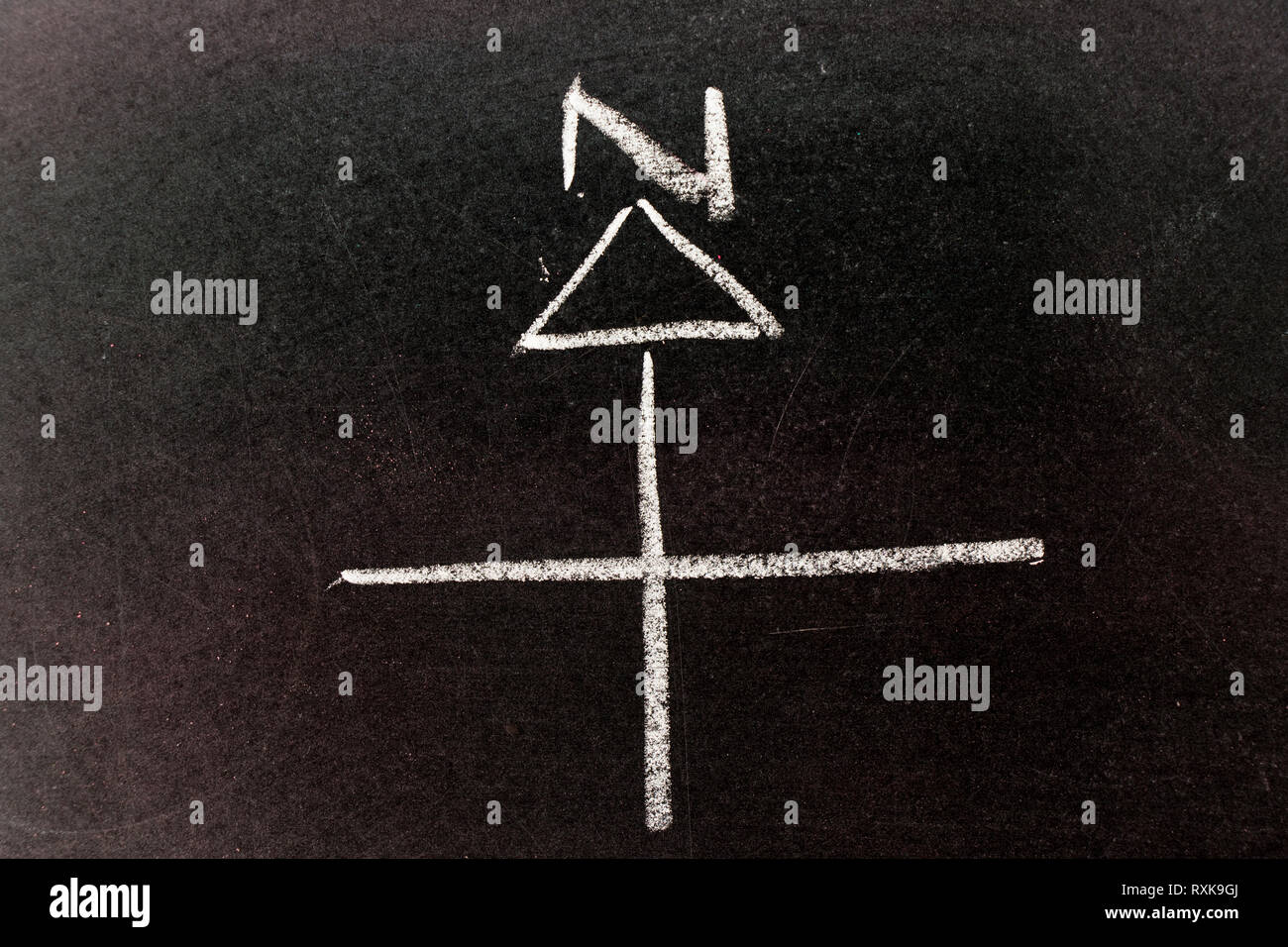 White chalk drawing in compass arrow, north direction shape on black