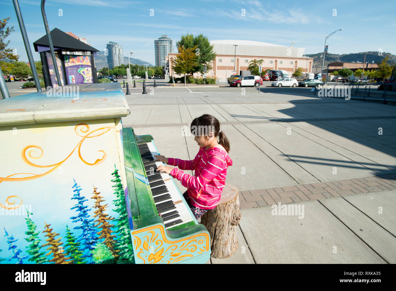 A young girl plays a public piano in Kelowna, British Columbia, Canada Stock Photo