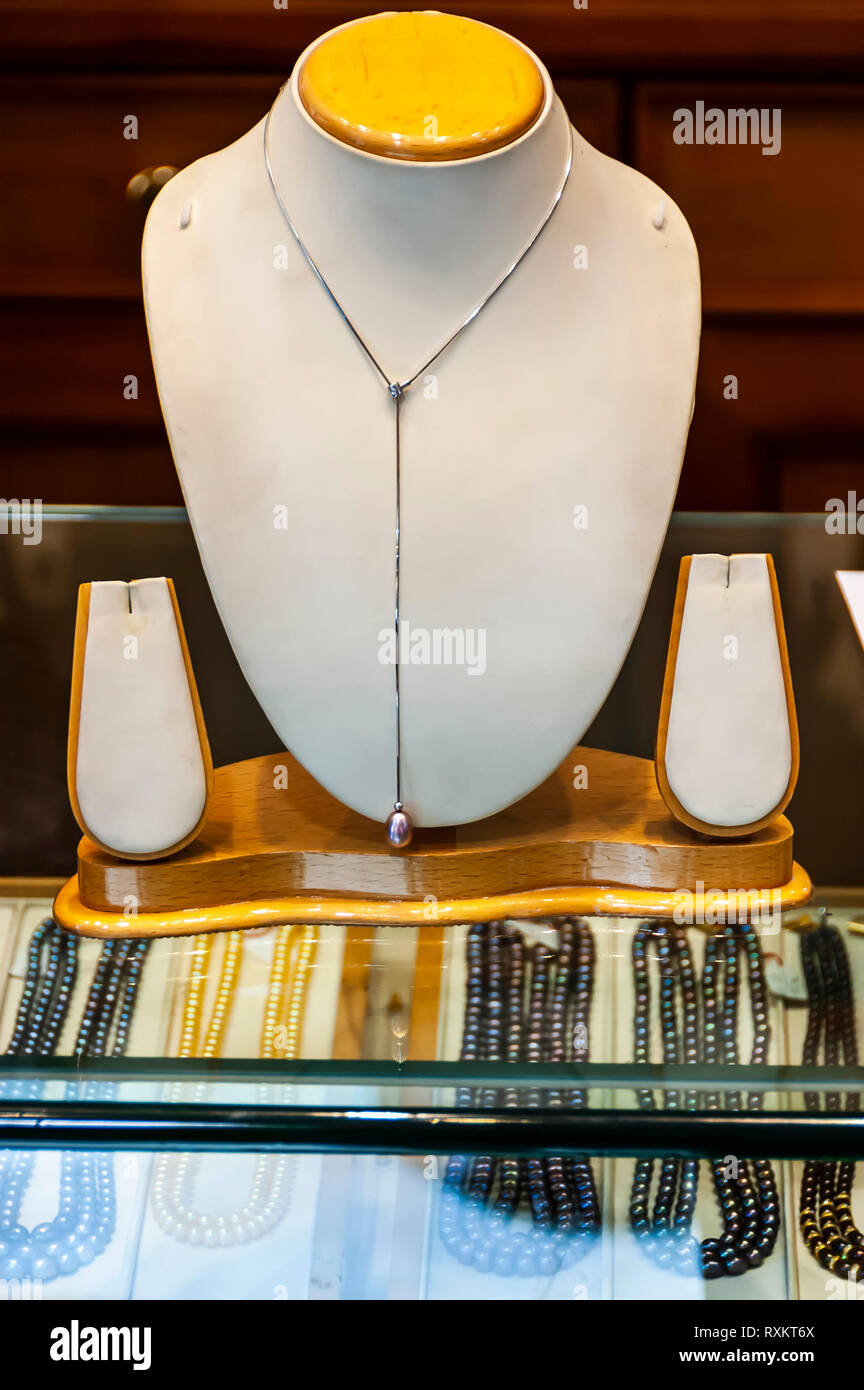 A white gold pearl necklace, hanging from a neck mold, on display for sale at one Hyderabad's many jewellery stores. Hyderabad, Telangana, India. Stock Photo