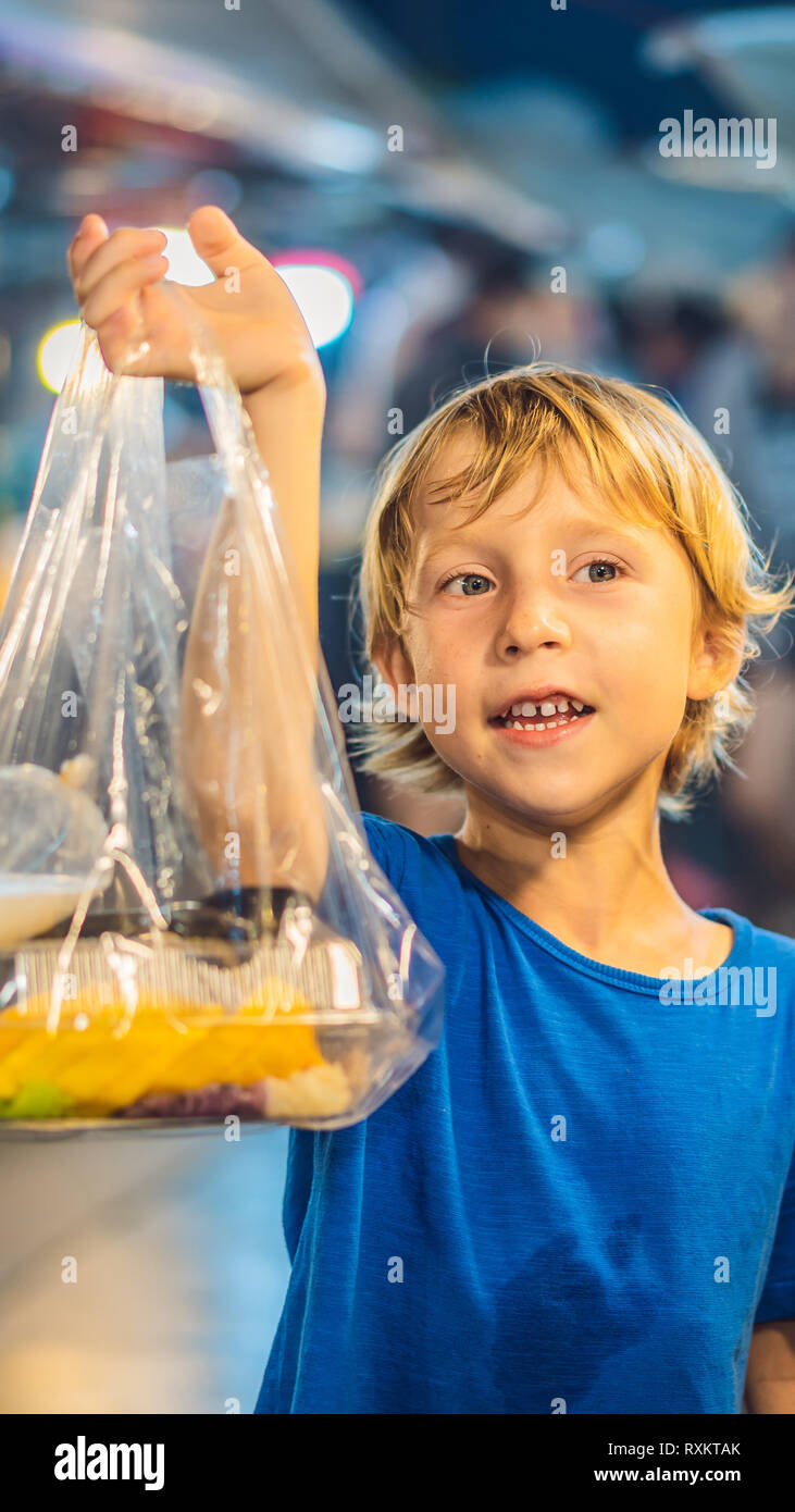 Young boy tourist on Walking street Asian food market VERTICAL FORMAT