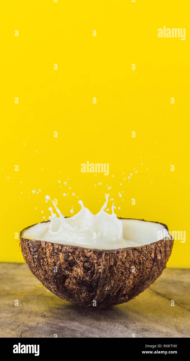 Coconut Fruit And Milk Splash Inside It On Yellow Background