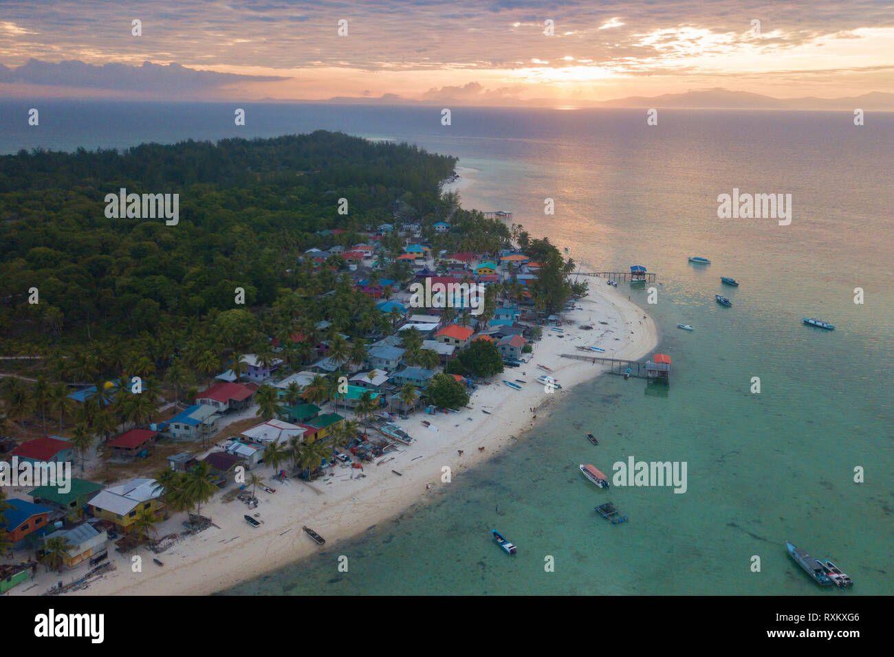 Sunrise at tropical island with village near beach front. Mantanani Island Sabah Malaysia Borneo. Stock Photo