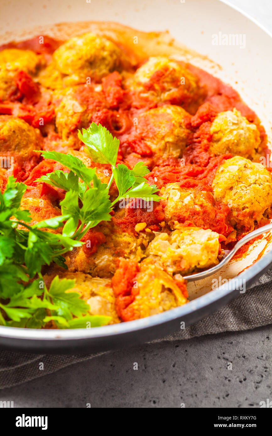 Baked vegan bean meatballs in tomato sauce with parsley. Plant based