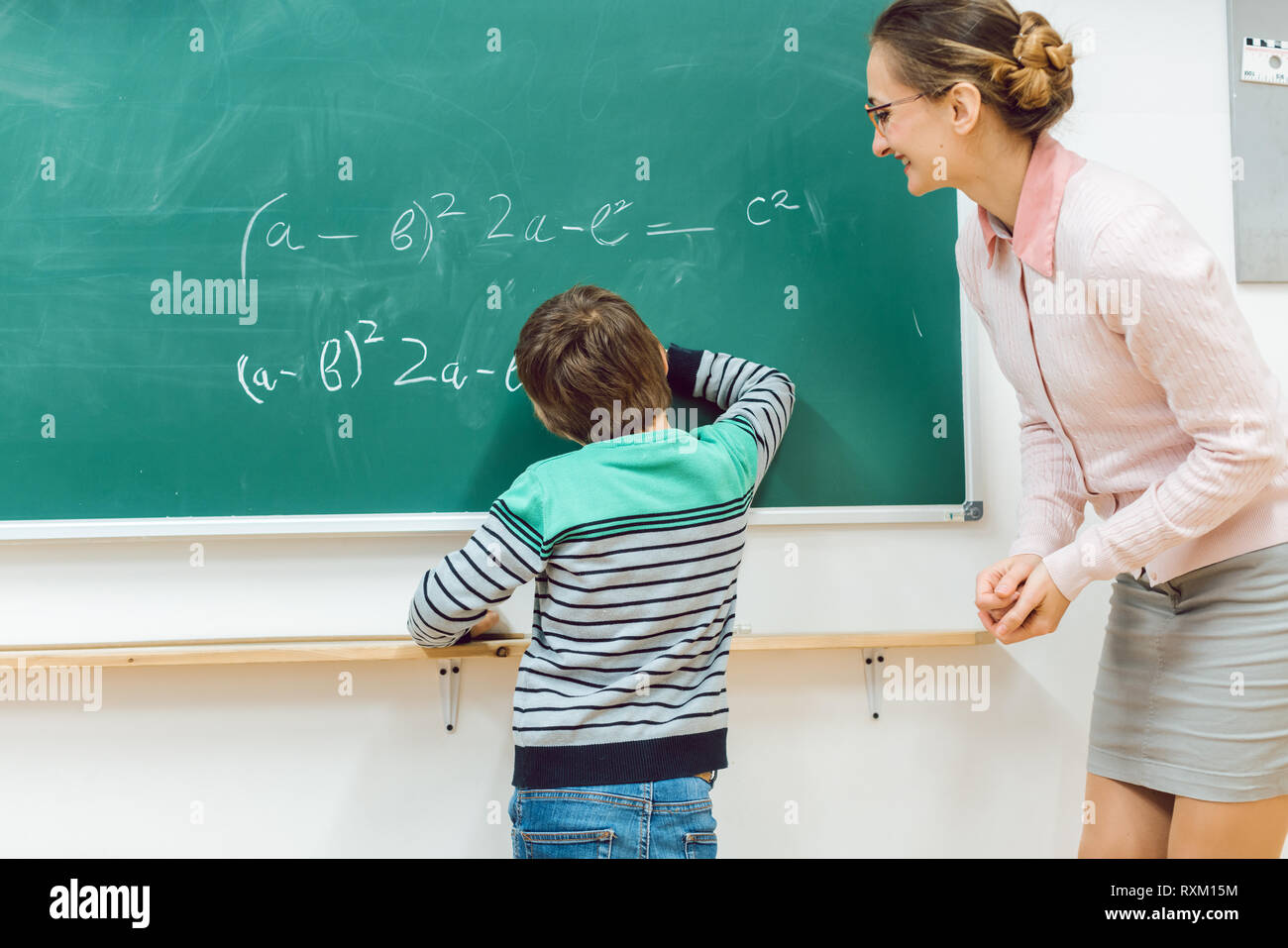 Student in school doing exercise at the blackboard Stock Photo Alamy