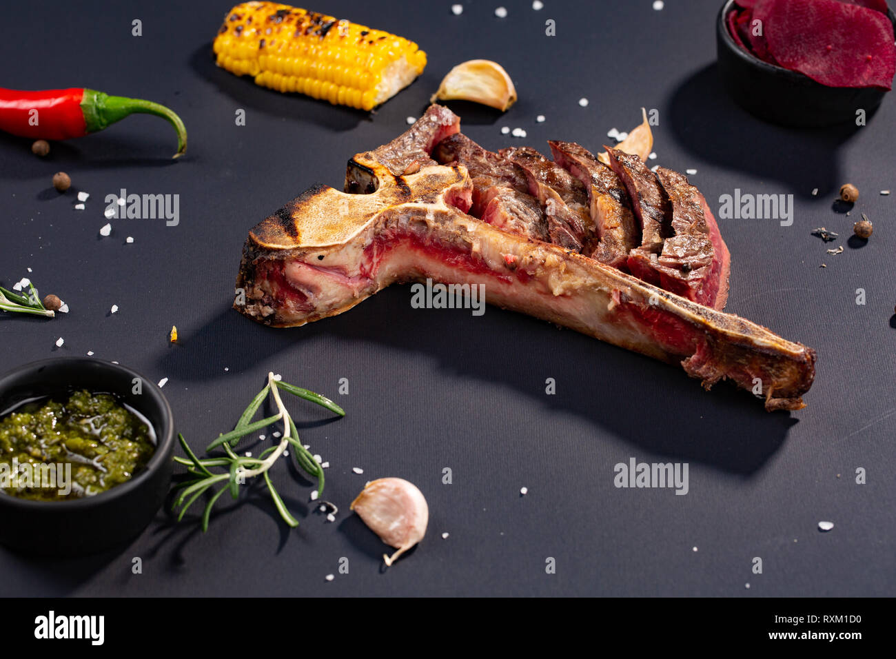 Set of grilled sliced Tbone steak with grilled corn, sauce, chilli