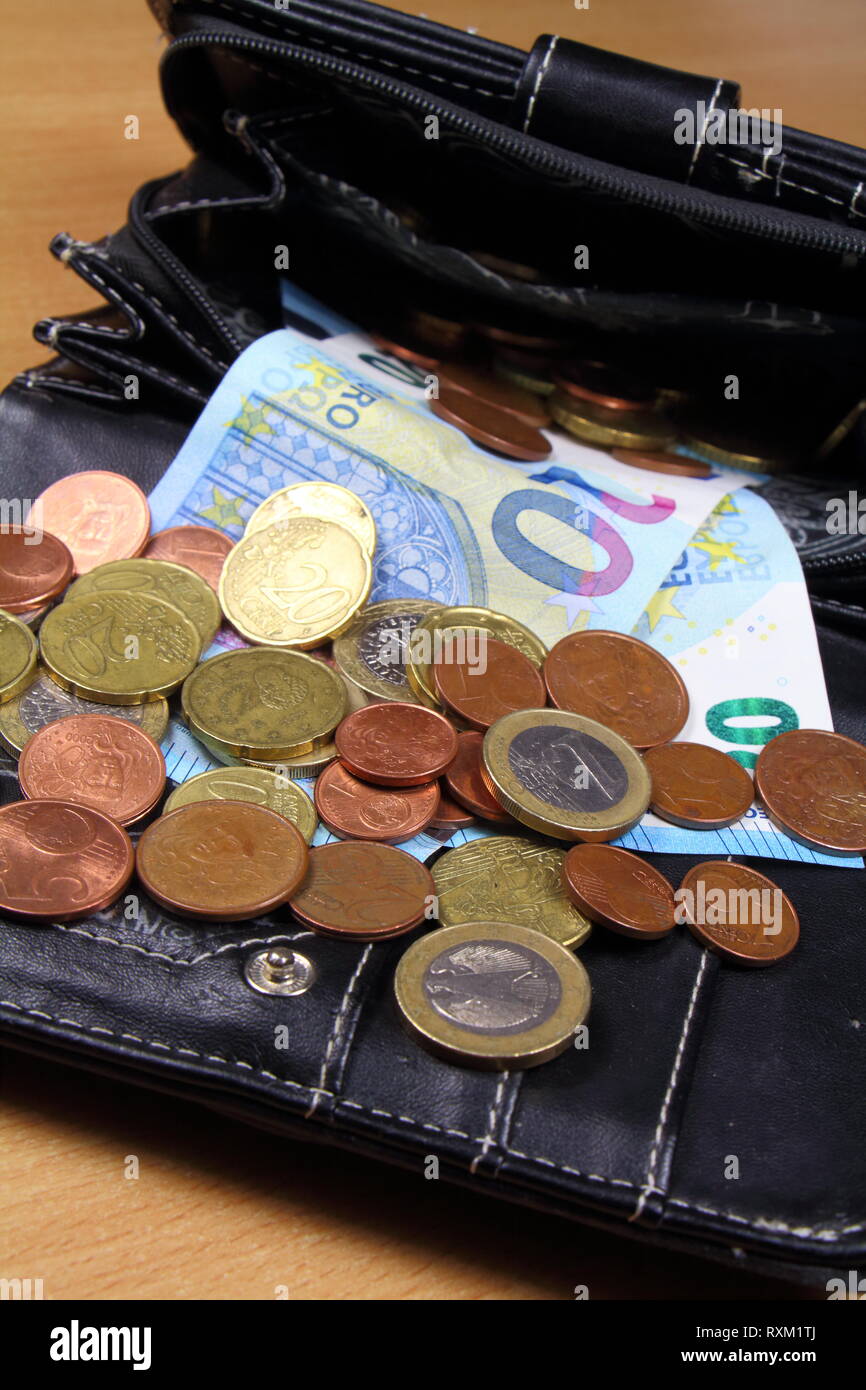 Euro coins and notes take out of a black leather purse Stock Photo
