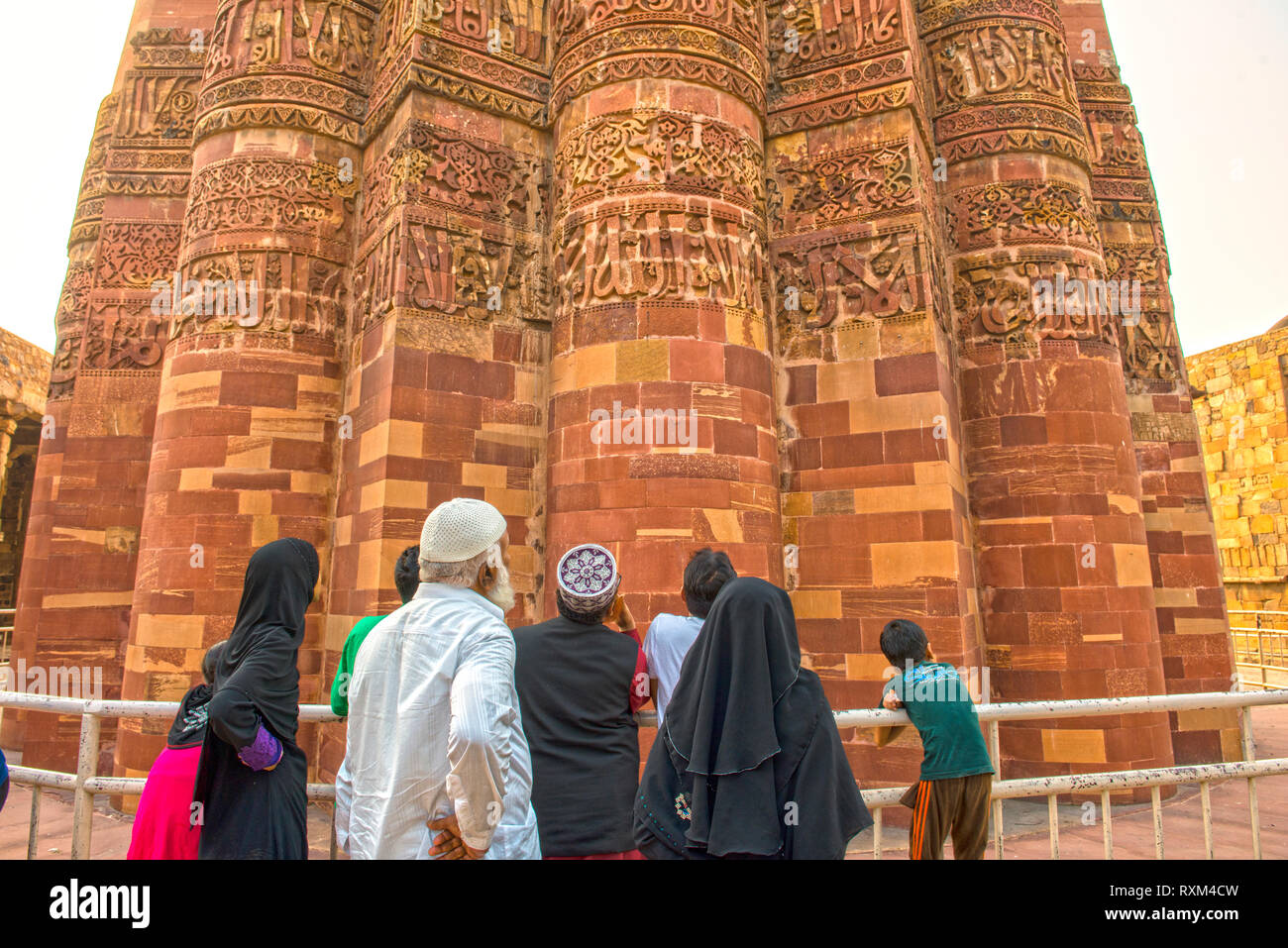 INDIA, NEW DELHI Muslim family studying the Kufi inscription of Qutb Minar, a tower of victory built around 1192 by Qutb-ud-din Aibak, the Stock Photo