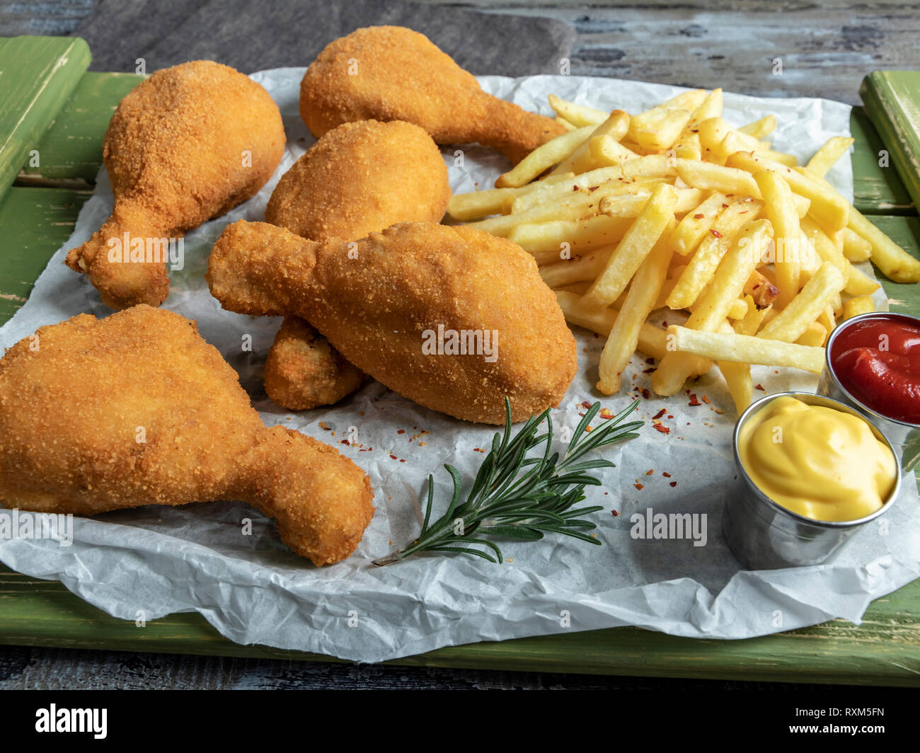 crispy fried chicken legs breaded golden color, french fries Stock Photo