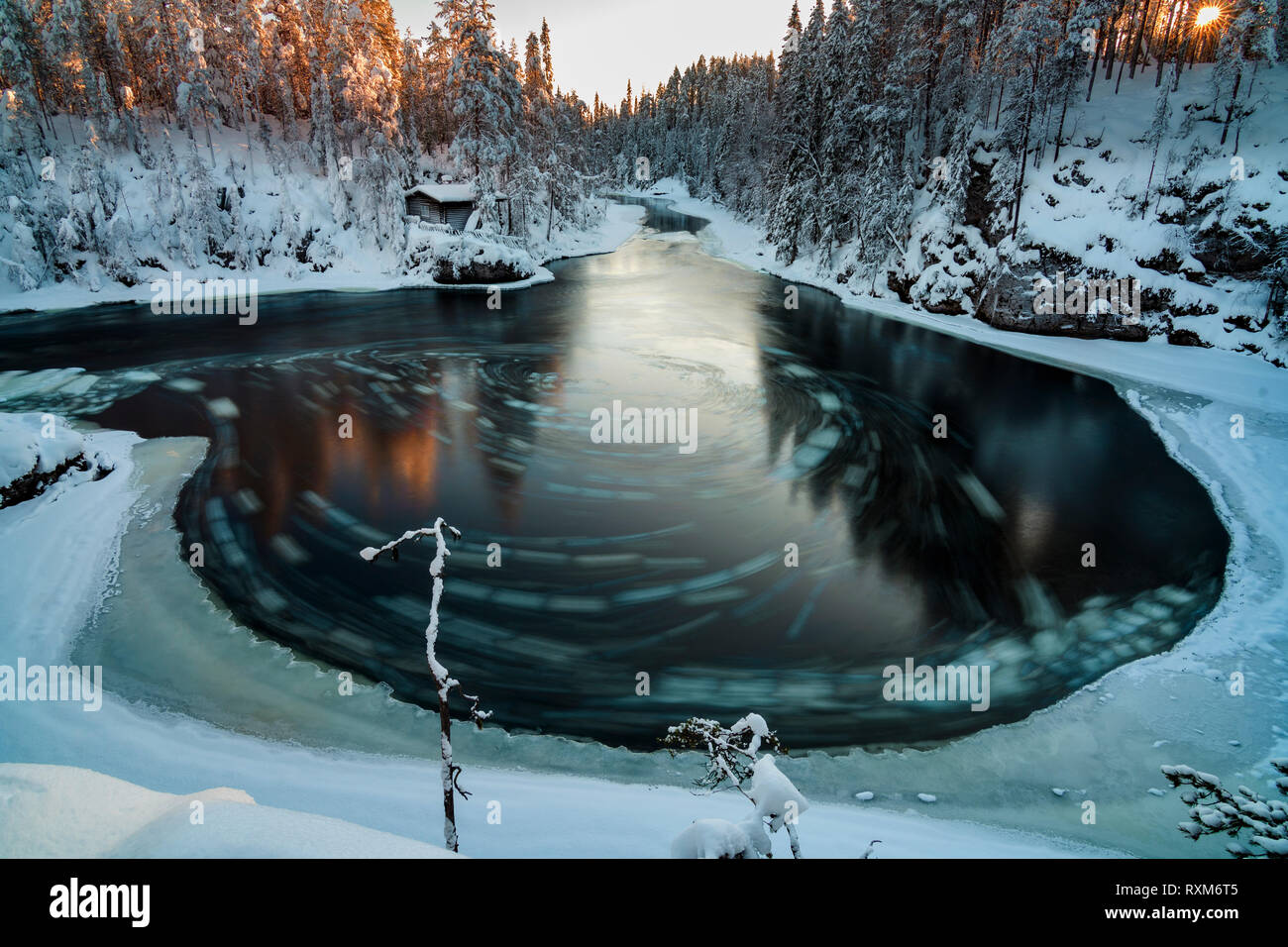 Winter landscape with a river with pieces of drifting ice making circles, Myllykoski, Oulanka National Park, Finland Stock Photo