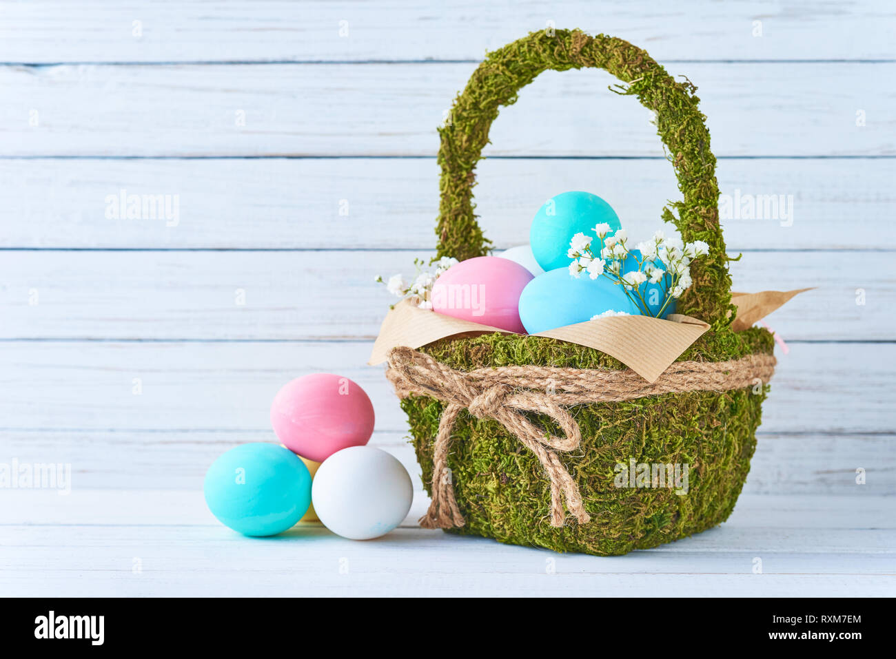 Colorful easter eggs in backet on white wooden background Stock Photo ...