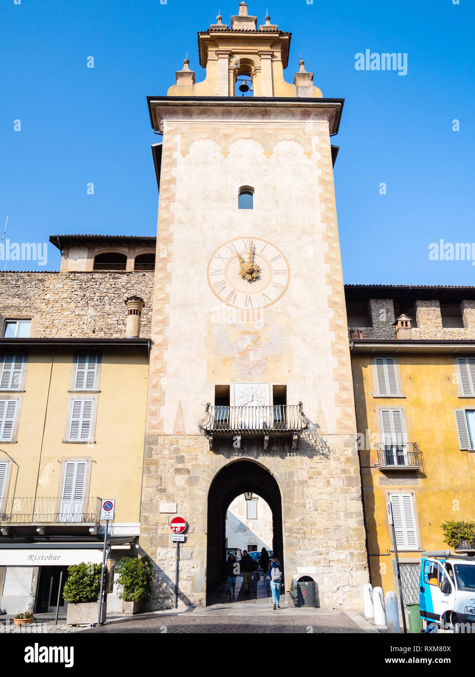 BERGAMO, ITALY - FEBRUARY 19, 2019: visitors walk in passage under the tower Torre della Campanella (Torre della Cittadella) on Piazza della Cittadell Stock Photo