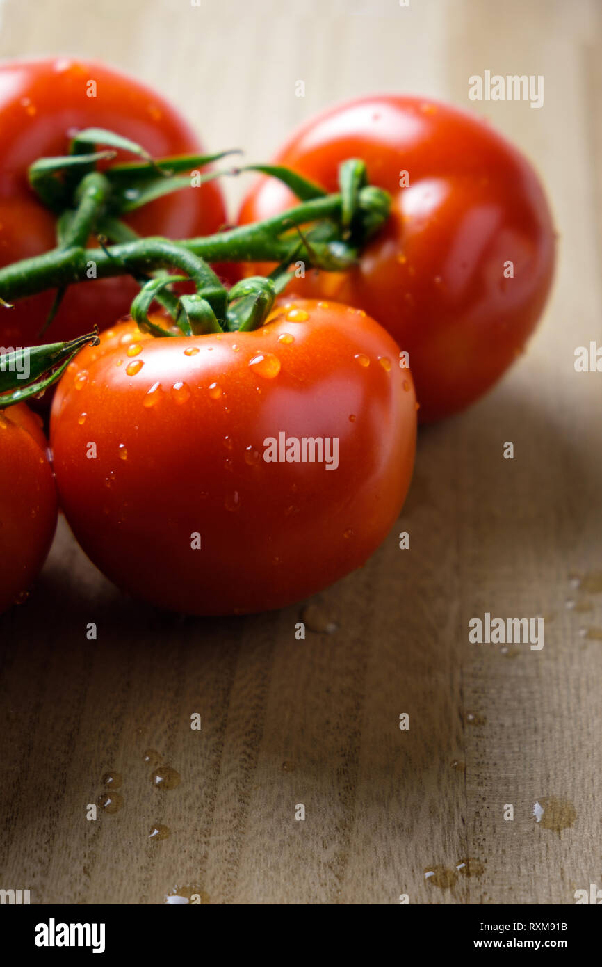 Tomatoes panicles on a wooden chopping board Stock Photo - Alamy
