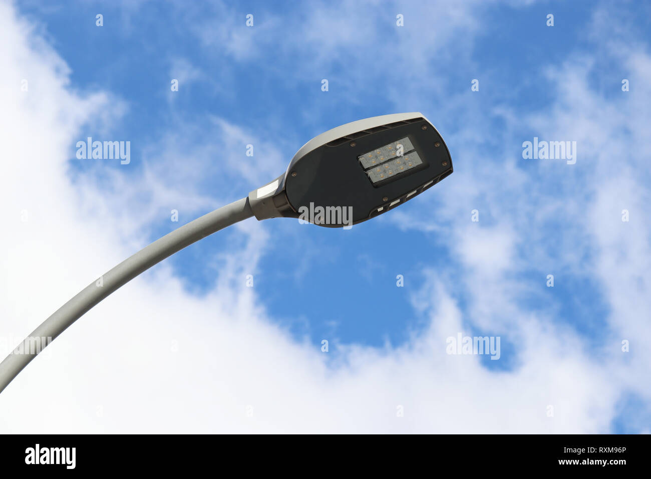 LED street lamp isolated on blue sky with white clouds. Modern led lights, saving electrical energy Stock Photo