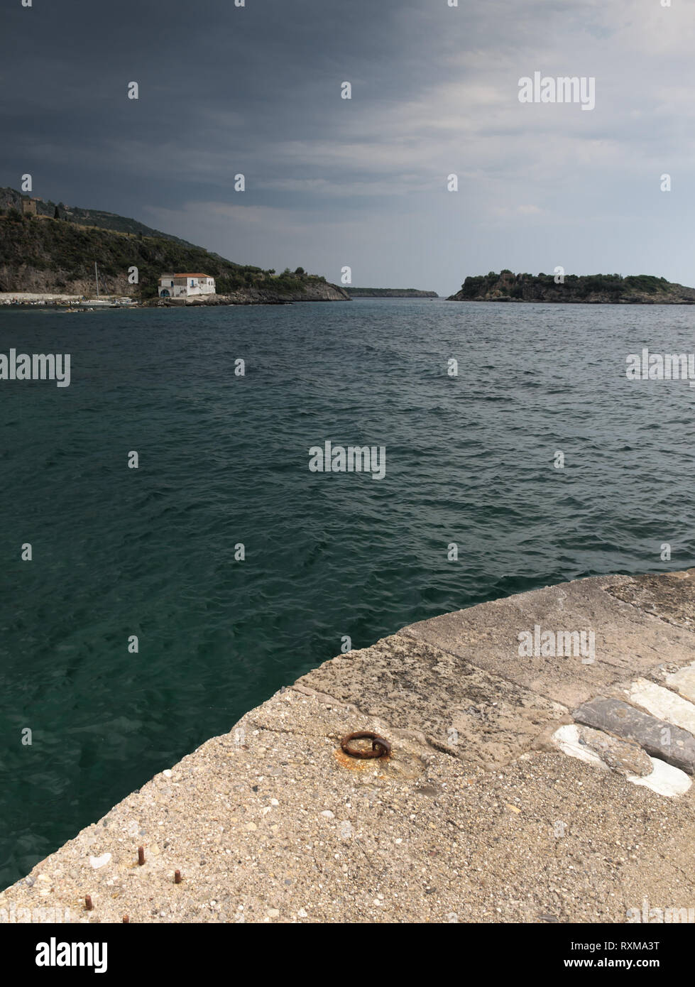 Port curved platform with under dramatic cloudy sky in Mani Greece. Stock Photo