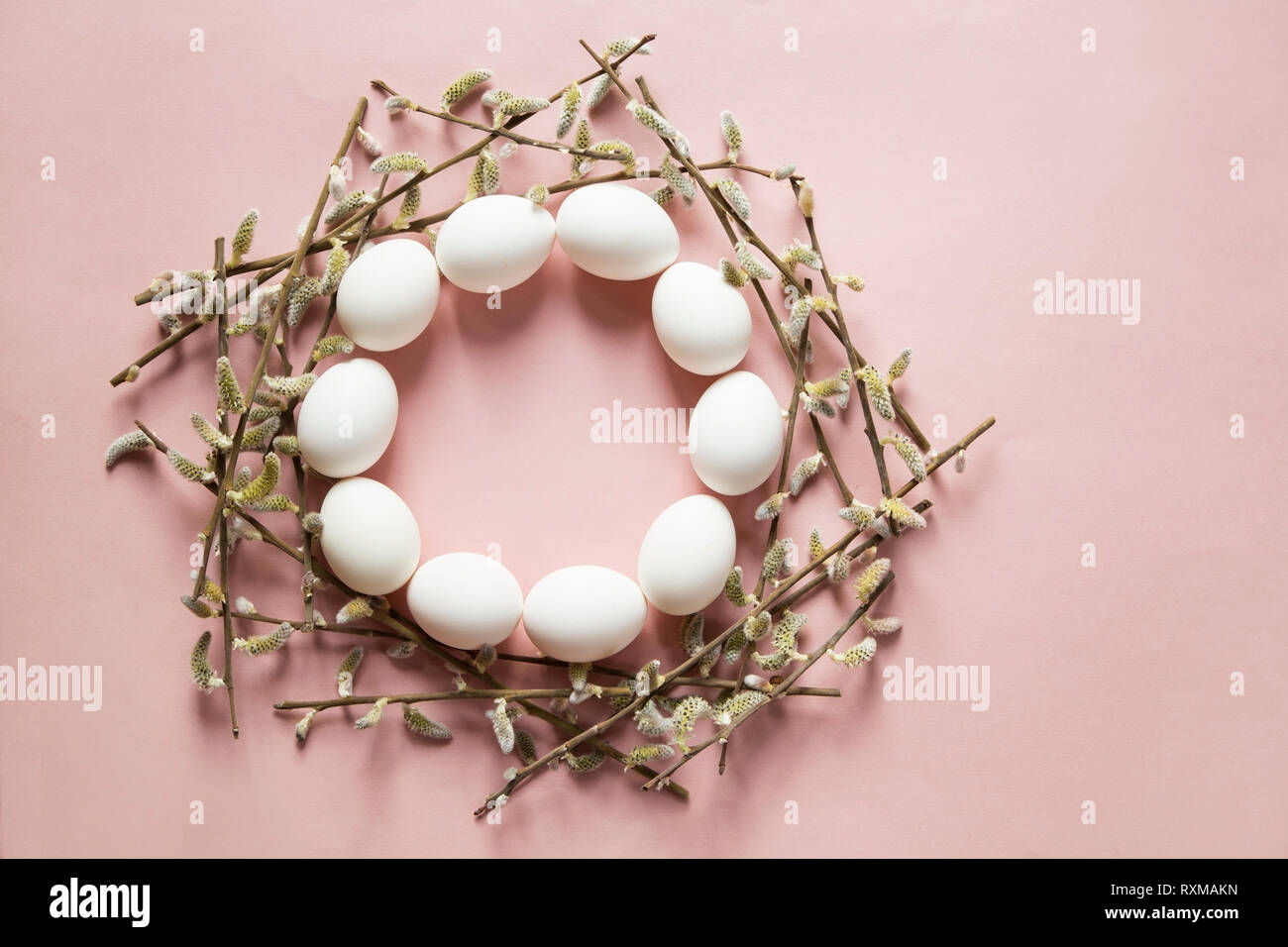 Eggs and willow branches on pink background Stock Photo