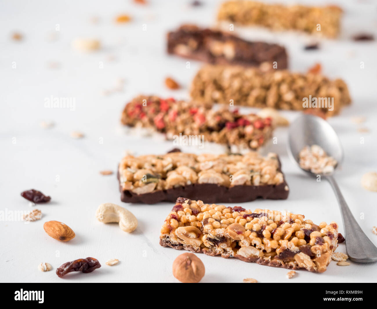 Granola bar with copy space. Set of different granola bars on white marble table. Shallow DOF. Stock Photo