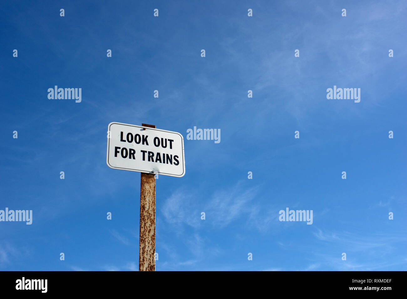 Abstract train warning sign with ‘Look out for trains’ in black