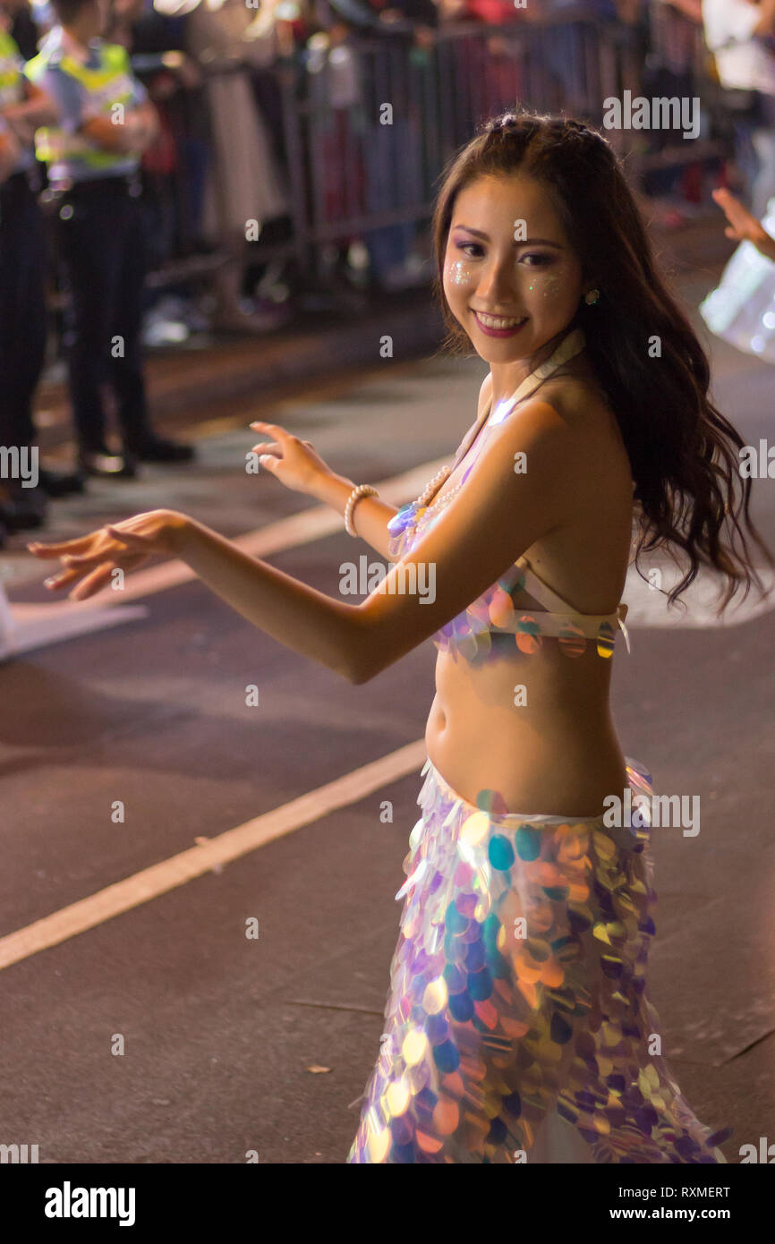 Attractive woman dancing as part of the Chinese New Year / Lunar New Year celebrations (Year of the Pig) in Kowloon, Hong Kong, China Stock Photo