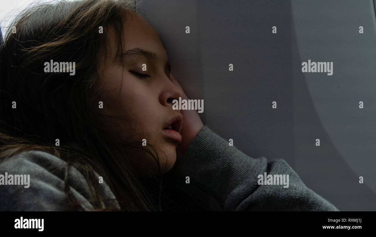 Young tween girl sleeping on airplane Stock Photo