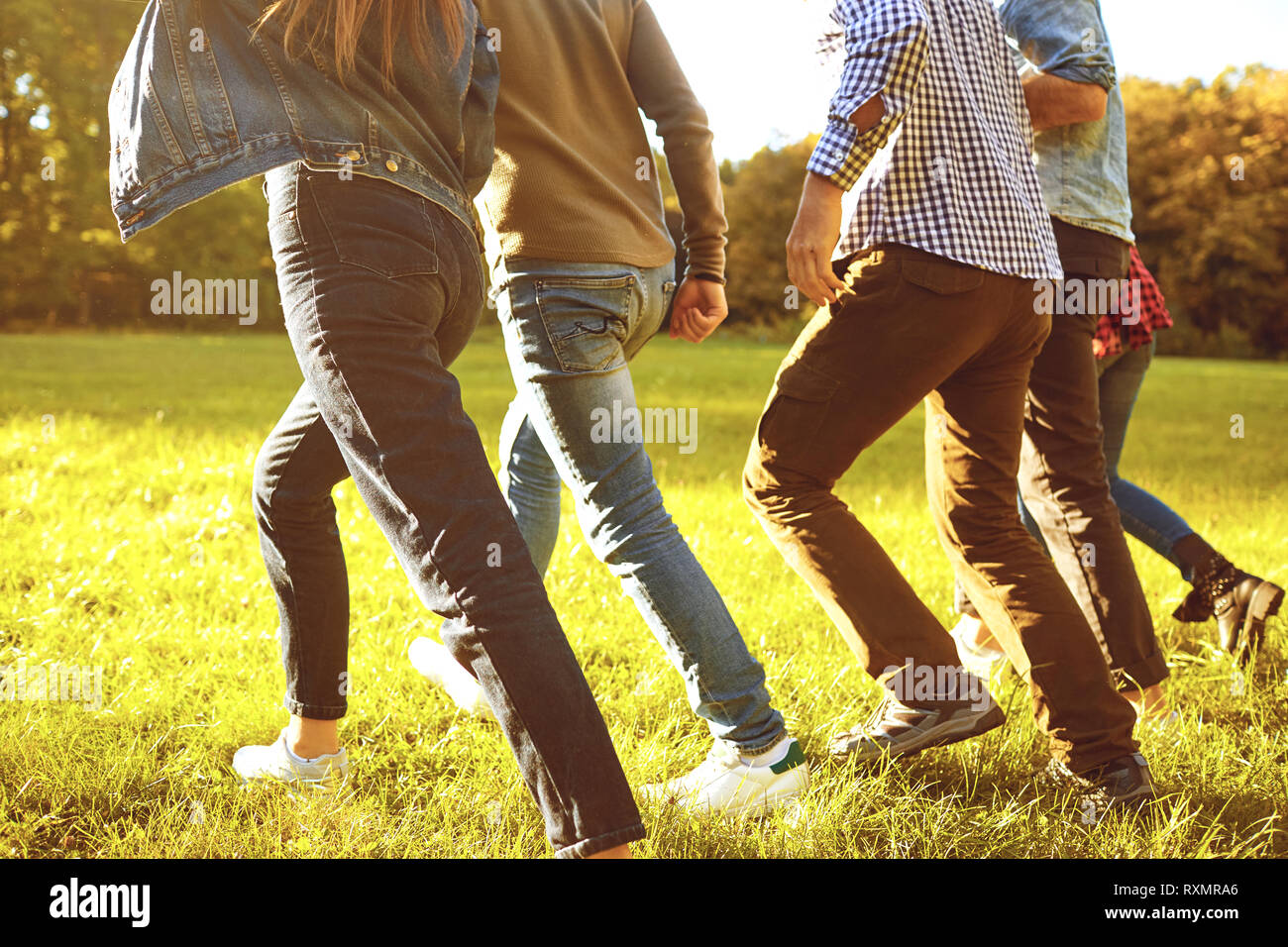 Legs of people running in the meadow. Stock Photo