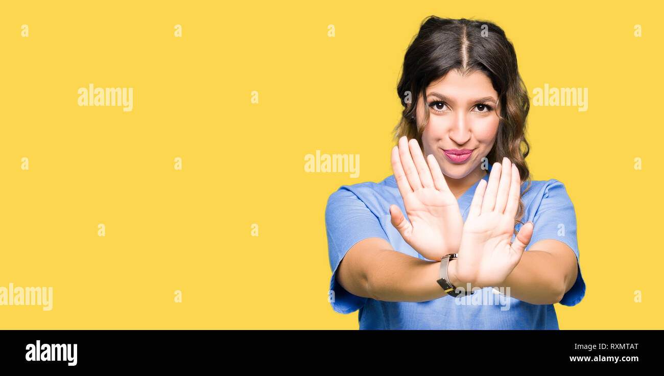 Young adult doctor woman wearing medical uniform Rejection expression ...