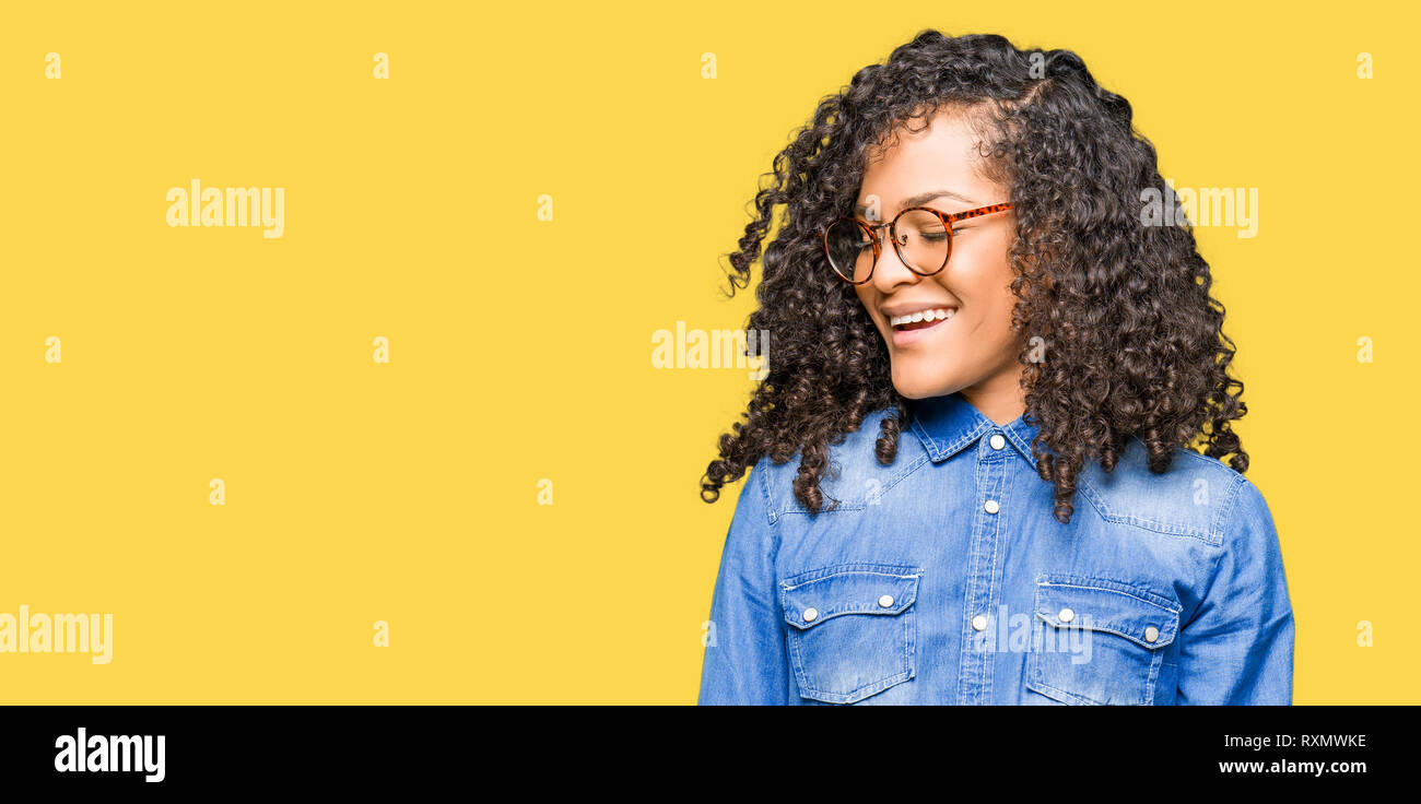 Young Beautiful Woman With Curly Hair Wearing Glasses Looking Away
