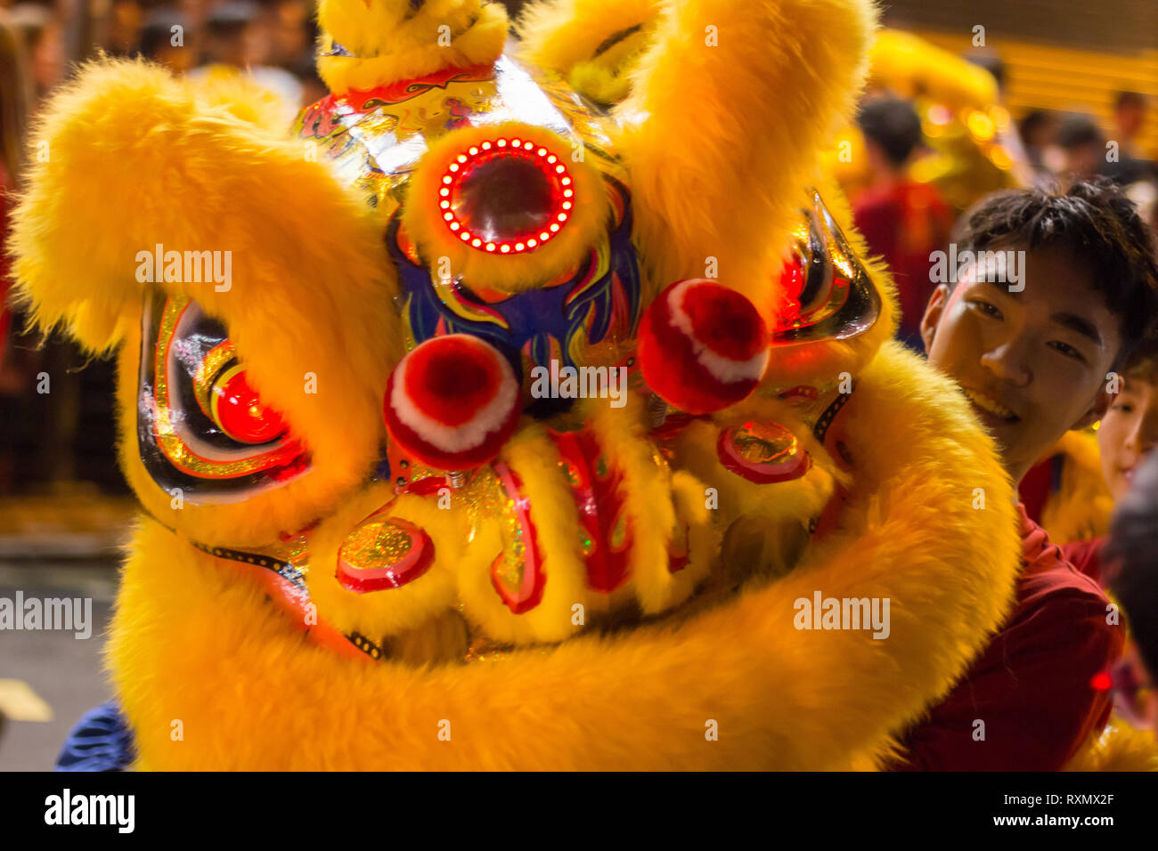 Man with Chinese dragon mask celebrating Chinese New Year (Lunar new year) celebrations in Kowloon, Hong Kong (Year of the Pig) Stock Photo