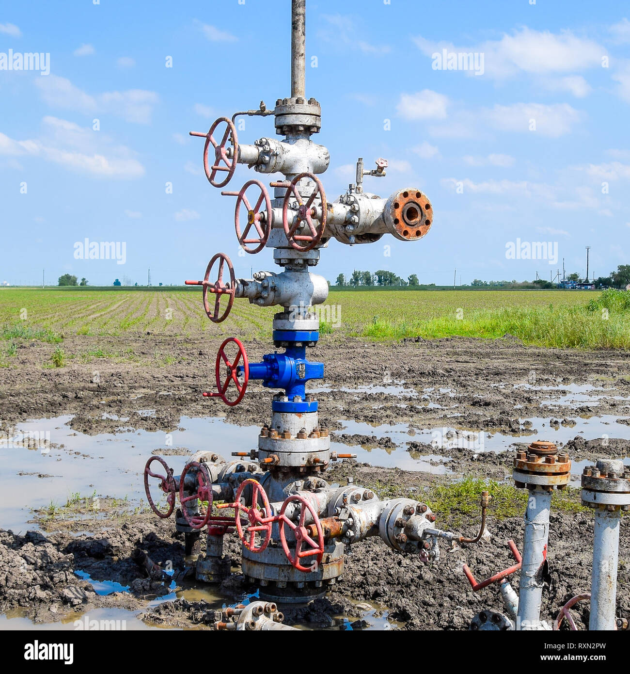 Oil well after repair in mud and puddles. Oil well wellhead equipment