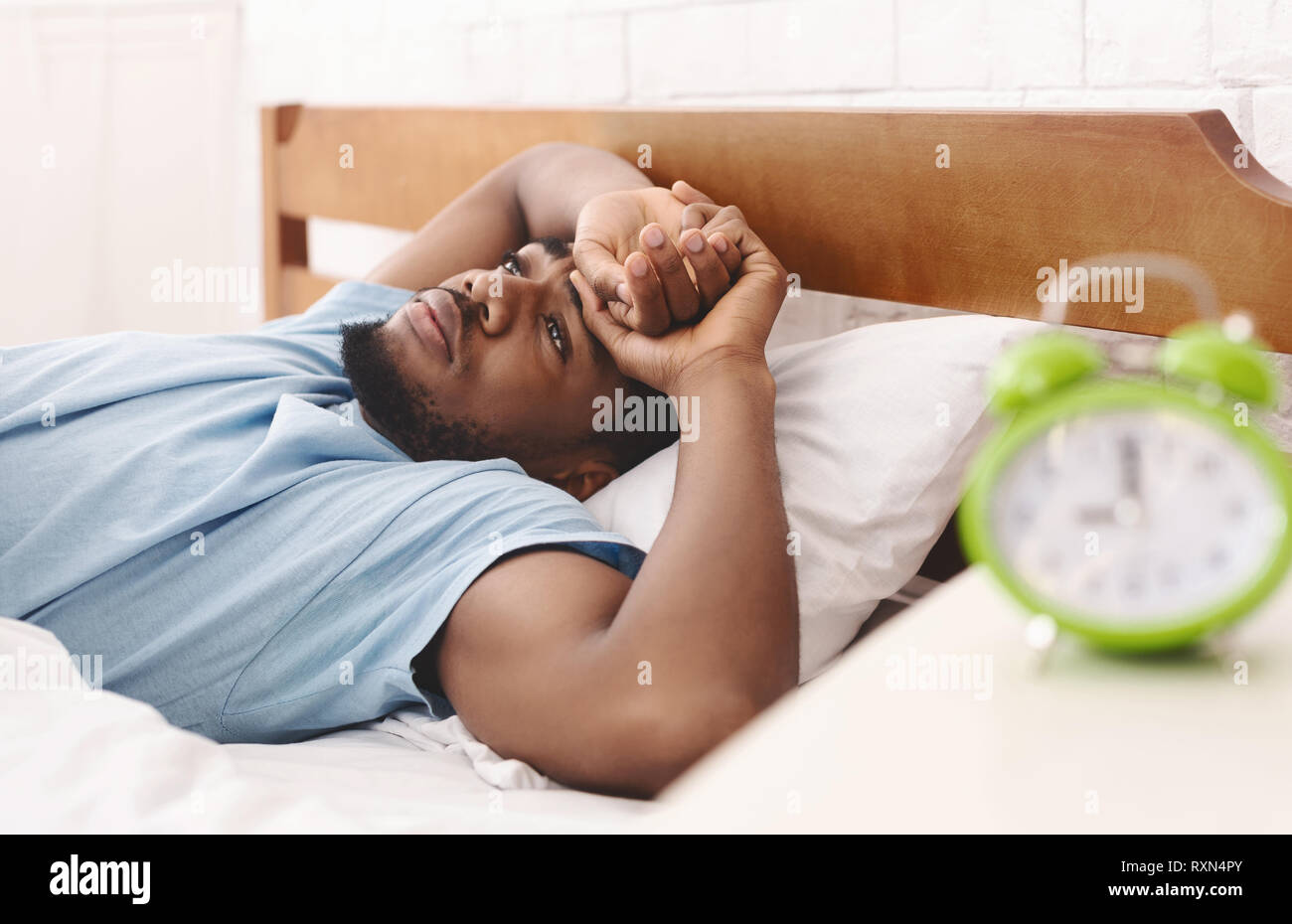 Black man in bed suffering from insomnia and sleep disorder Stock Photo