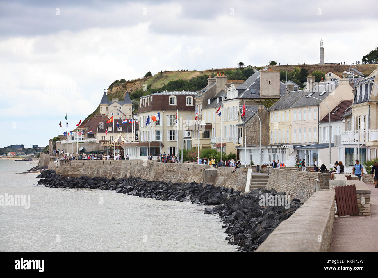 Walking path on the water's edge in the tourist town of Arromanches-les-Bains which played an important role during the D-Day landing in WWII, Normandy, France Stock Photo