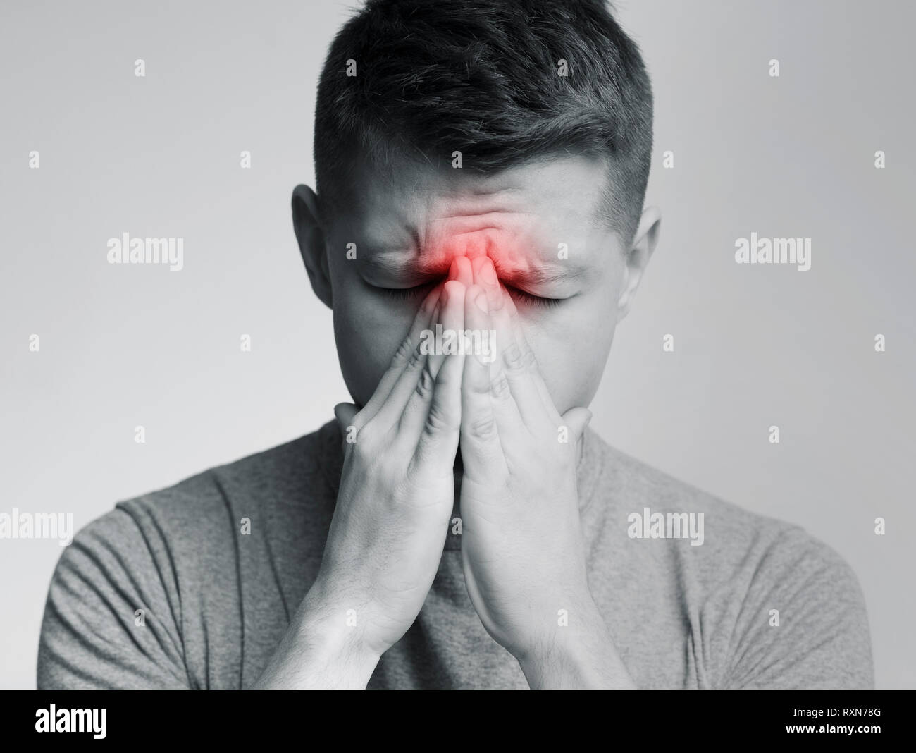 Sad man holding his nose because sinus pain Stock Photo