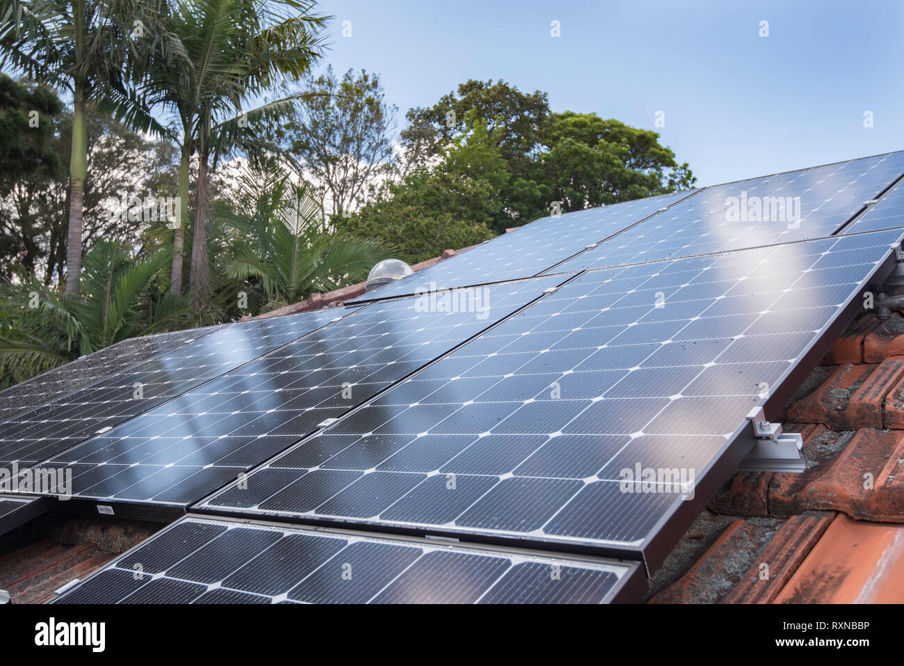 An array of roof top solar photo voltaic (PV) panels on a home in Sydney Australia. These panels are all installed with individual micro inverters. Stock Photo