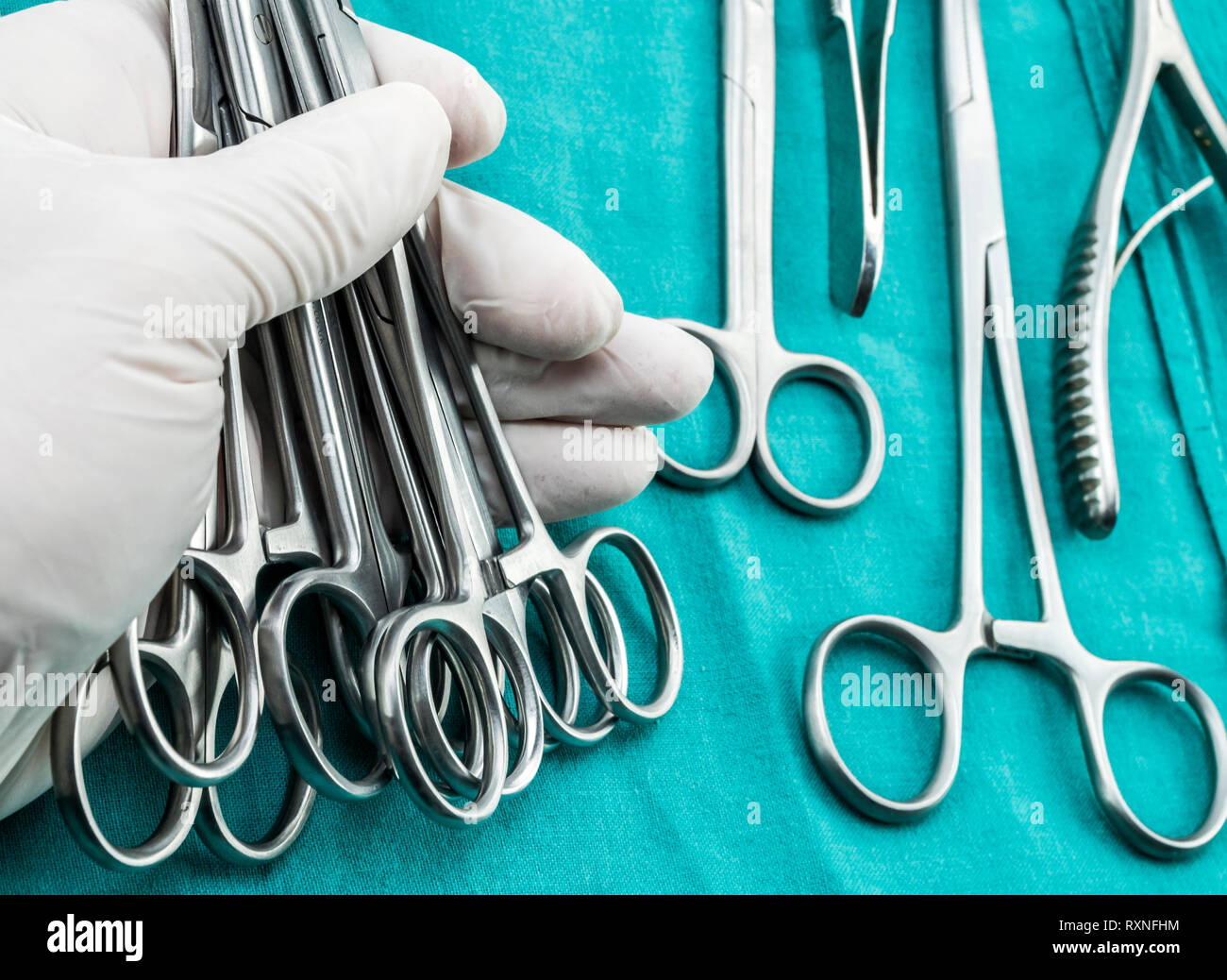 Surgeon working in operating room, hands with gloves holding scissors sutures, conceptual image, composicon horizontal Stock Photo