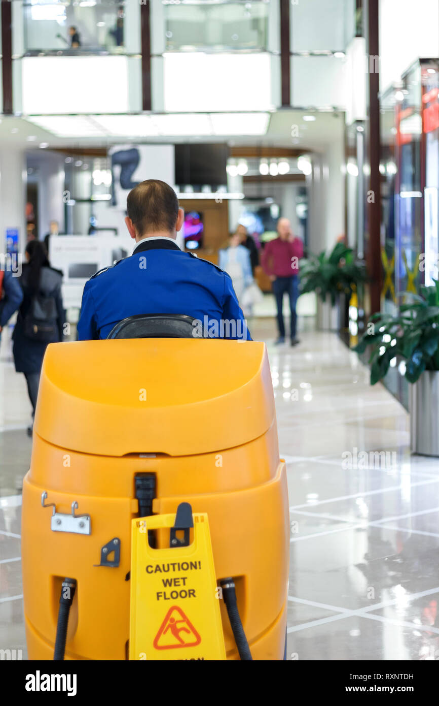 Cleaner in blue uniform at the cleaning machine in the shopping mall Stock  Photo - Alamy
