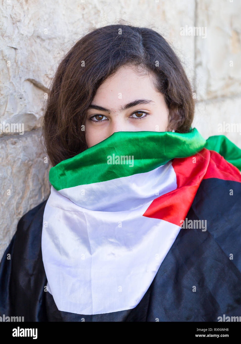 A portrait photo of Palestinian little girl masked with Palestinian flag, Gaza City Palestine. Stock Photo