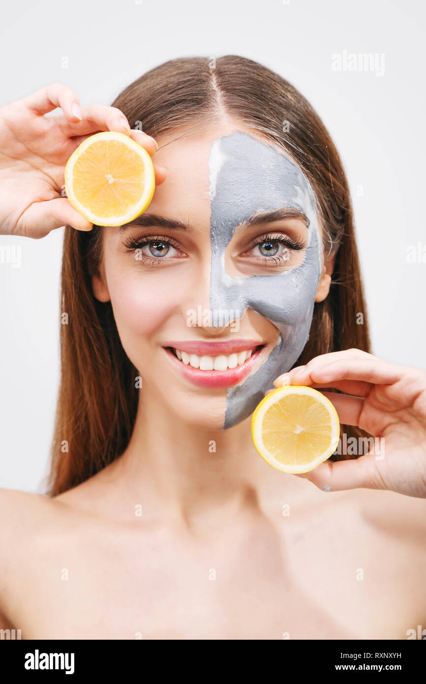 Funny beautiful model holding lemon slices up to her eyes Stock Photo