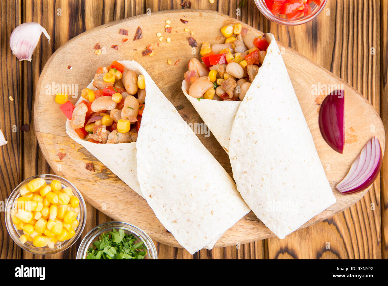Burrito in tartilla with meat, vegetables, white beans, red pepper