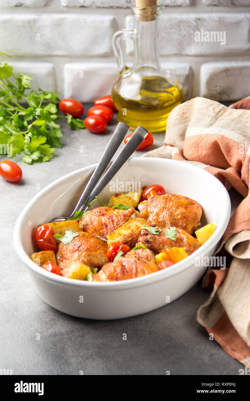 Baked chicken thighs (legs) with crispy crust, potatoes and cherry