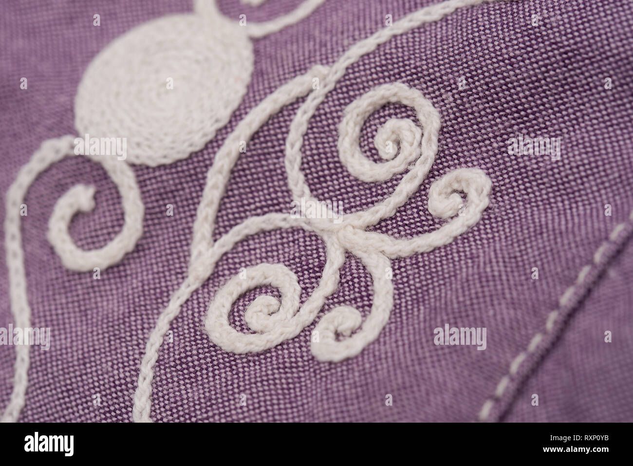 white embroidery on violet textile, dress detail Stock Photo