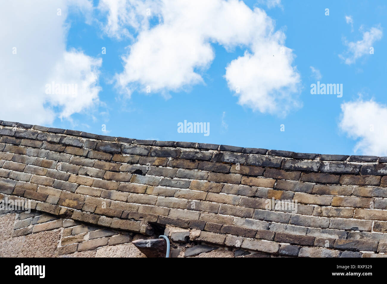 Sky clouds over stone fence Stock Photo