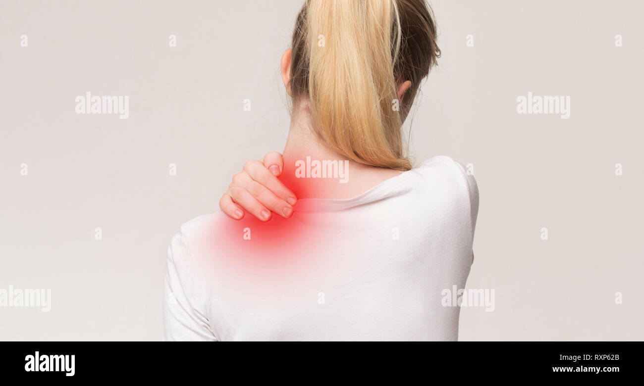 Unhappy woman suffering from pain, massaging neck Stock Photo - Alamy