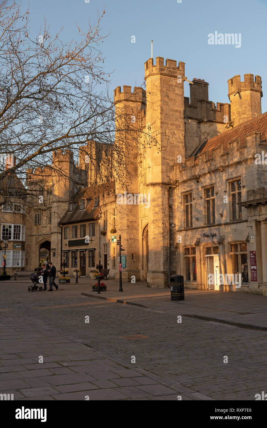 Wells, Somerset, England, UK. March 2019. Glowing sun illuminates the Market Place,and Bishops Eye Gatehouse and Penniless Porch  in the cathedral cit Stock Photo