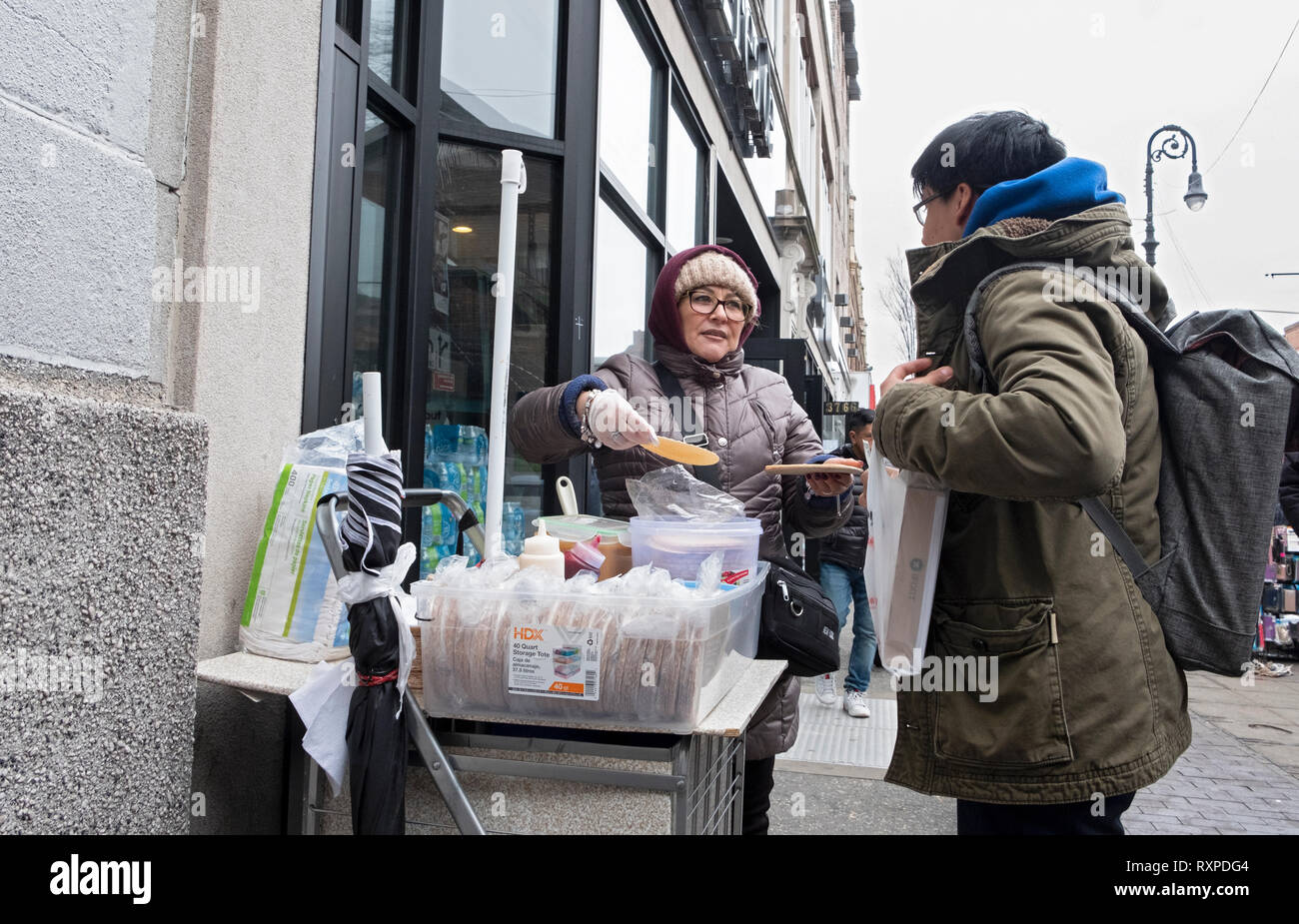 A Latin American woman selling obleas, a Mexican wafer pastry, covered with cajera, a thick sweet syrup. On 82nd S.t in Jackson Heights, Queens, NYC. Stock Photo