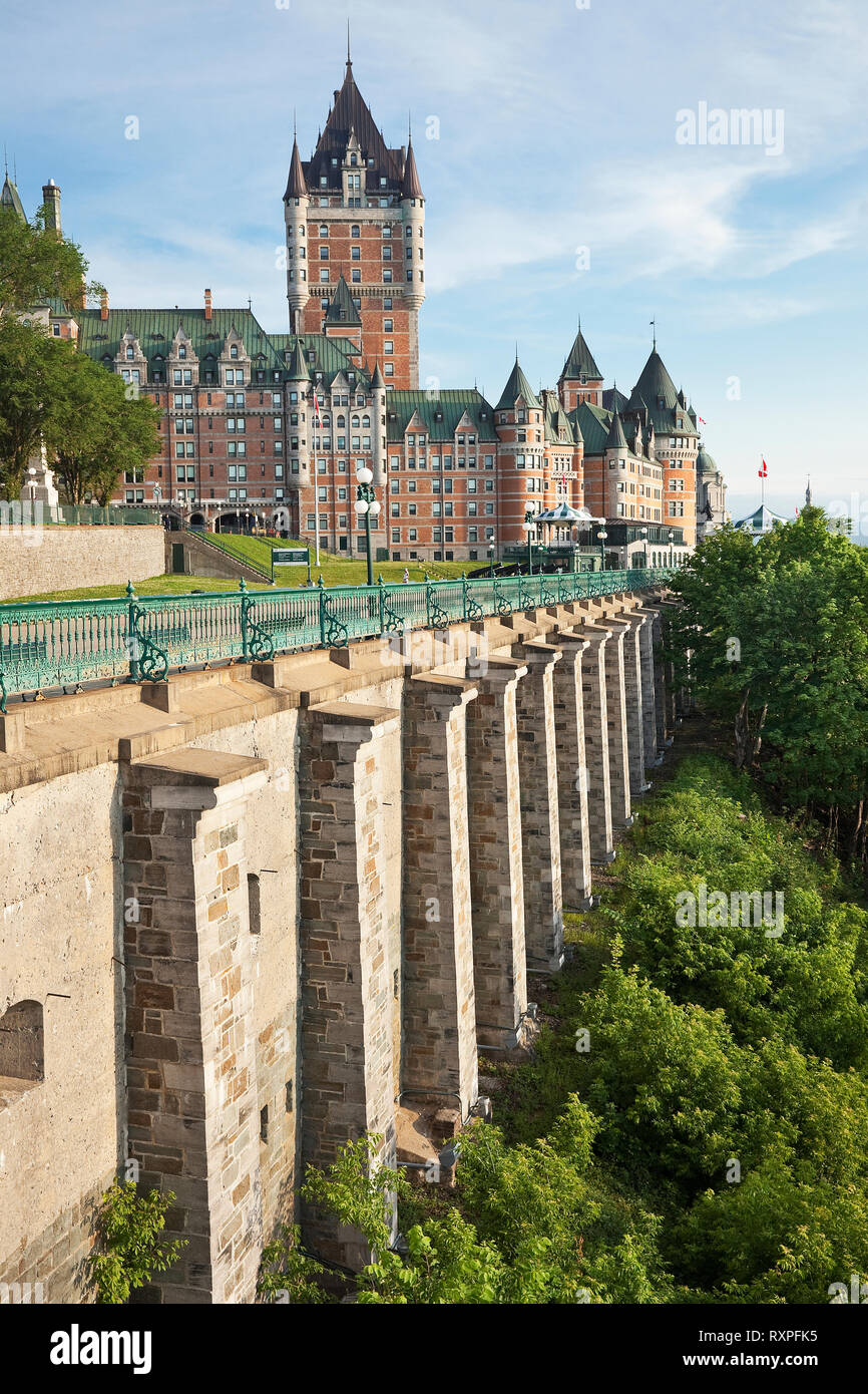 Very high stone walls providing support for Dufferin Terrace, a popular boardwalk offering a spectacular view of the St. Lawrence River. In the background is Chateau Frontenac, Old Quebec City, Province of Quebec, Canada Stock Photo
