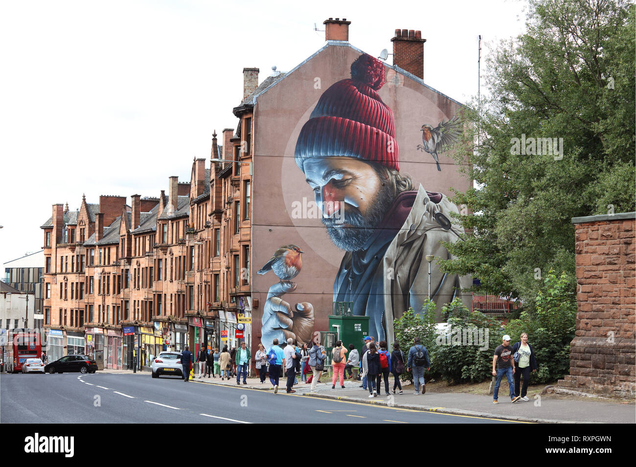 Mural on High St. by street artist Sam Bates, aka Smug, depicting St. Mungo the patron saint and founder of the City of Glasgow, Scotland Stock Photo