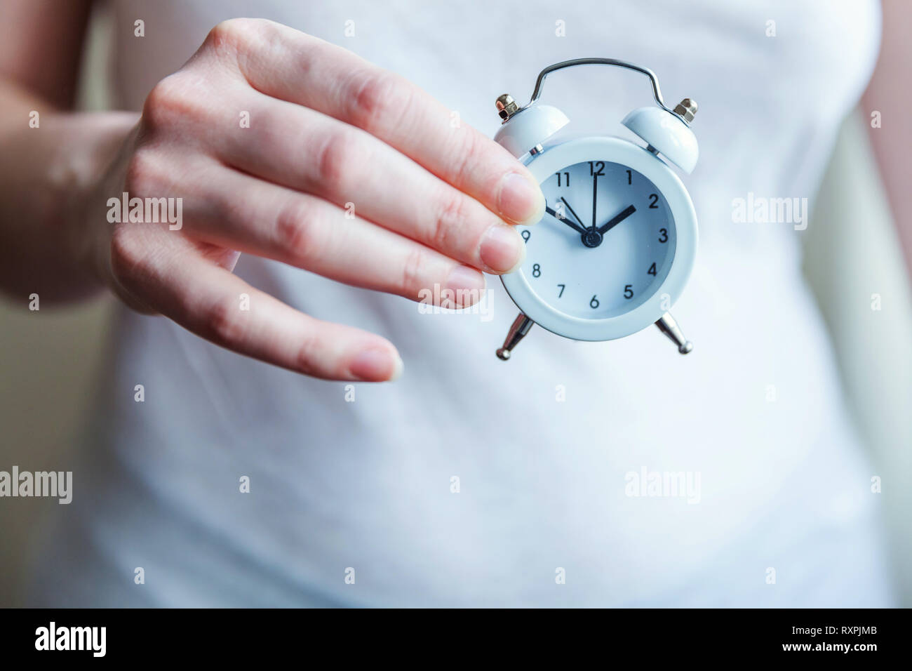 Female woman hands holding ringing twin bell vintage classic alarm