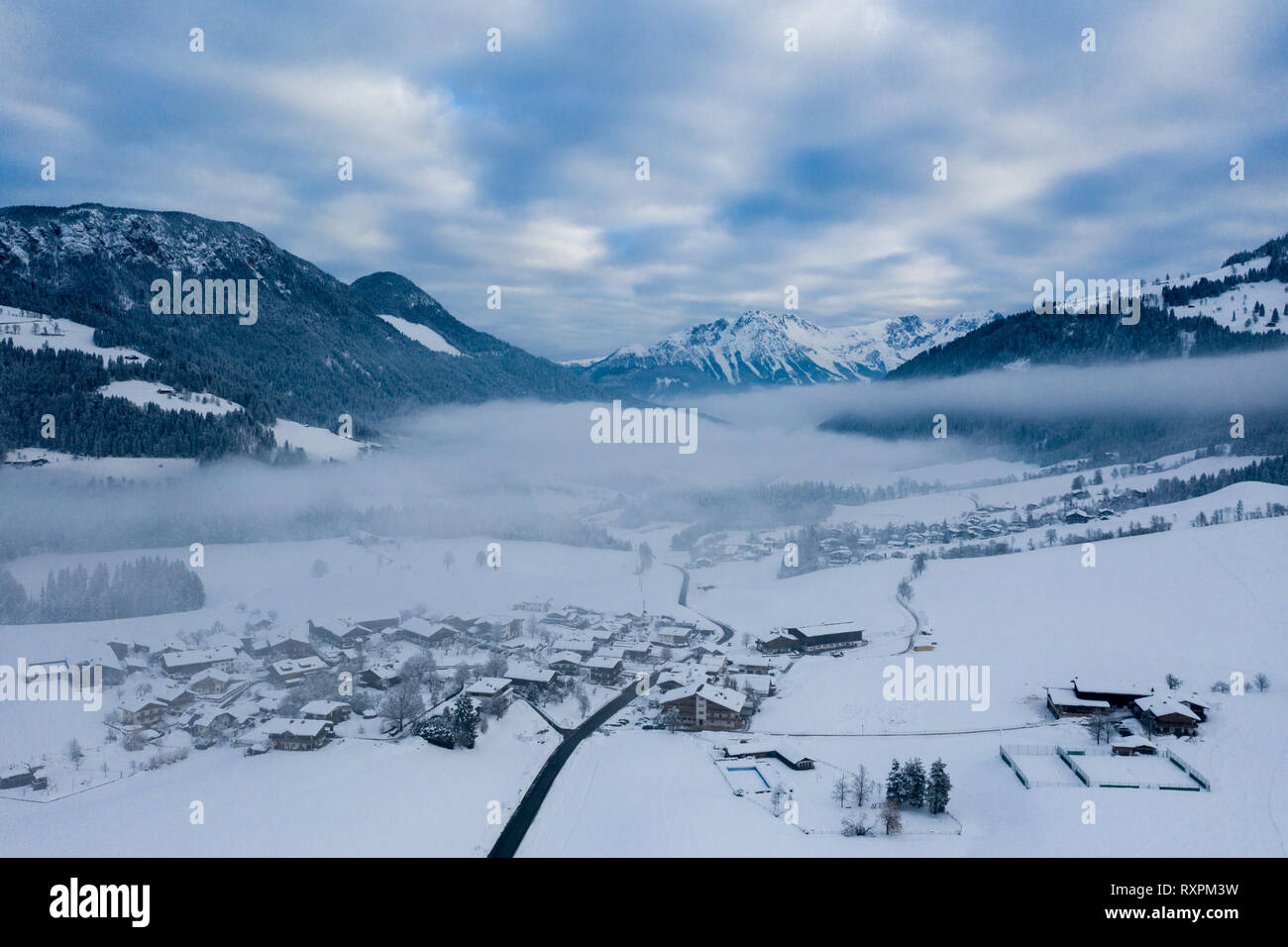 Morning foggy top aerial panoramic view of snow and village with trees ...