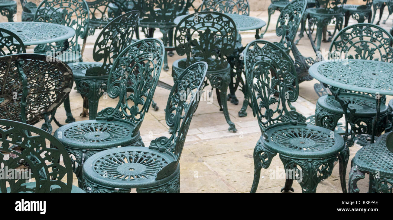 Full size view on many crested and figured metal chairs and tables. Green-blue color. Stock Photo